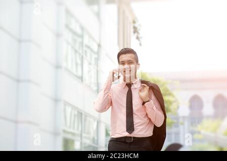 Junge Unternehmer, am Telefon zu sprechen, gehen auf die Straße der Stadt. Stockfoto