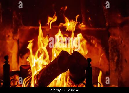 Feuer brennt im Kamin, angetrieben von Holzstämmen. Stockfoto