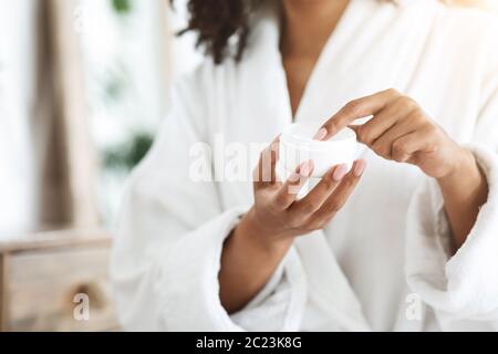 Unerkennbare schwarze Frau hält Glas mit Bio-natürliche Creme in den Händen Stockfoto