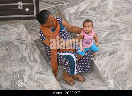 Beawar, Rajasthan, Indien, 16. Juni 2020: Eine indische Mutter mit ihrem Baby sitzt außerhalb ihres Hauses während der fünften Phase der laufenden landesweiten COVID-19-Sperre, in Beawar. Kredit: Sumit Saraswat/Alamy Live Nachrichten Stockfoto