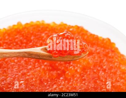 Kleine Löffel aus Holz mit gesalzener russischen roten Kaviar von sockeye Lachs Fisch über Kunststoffbehälter mit roten Roe von rosa Lachs isoliert auf weißem backgro Stockfoto
