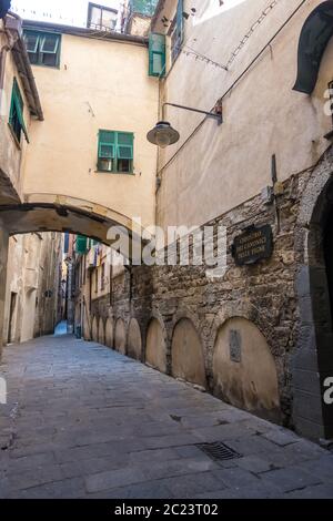 Genua, Italien - 20. August 2019: Alte Straße mit Schildern von Geschäften und Cafés in Genua, Ligurien Region Stockfoto