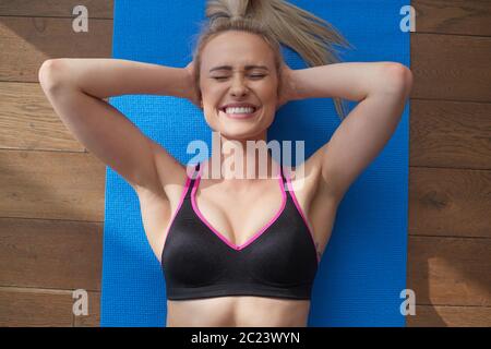 Fitness bestimmt mittleren Alters Frau liegend tun knirscht zu Hause auf Turnhalle Matte Stockfoto