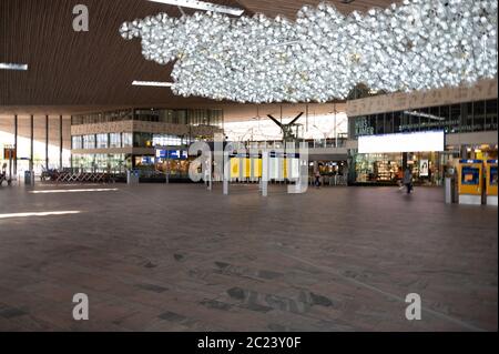 Hauptatriumhalle des Rotterdamer Hauptbahnhofs in den Niederlanden. Geschäfte und Menschen sind während der Covid-Sperre gut sichtbar Stockfoto