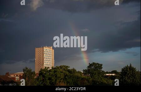 Merton, London, Großbritannien. 16. Juni 2020. Hinter dem Londoner Stadtbezirk Merton Civic Center, das derzeit in der Coronavirus-Sperre geschlossen ist, bildet sich das Ende eines Regenbogens gegen graue Wolken nach einem warmen Tag in London. Quelle: Malcolm Park/Alamy Live News. Stockfoto