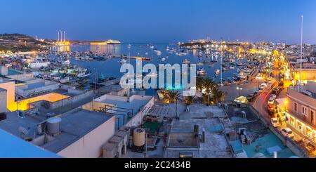 Luftpanorama Blick auf den Hafen des mediterranen Fischerdorfes Marsaxlokk bei Nacht, Malta Stockfoto