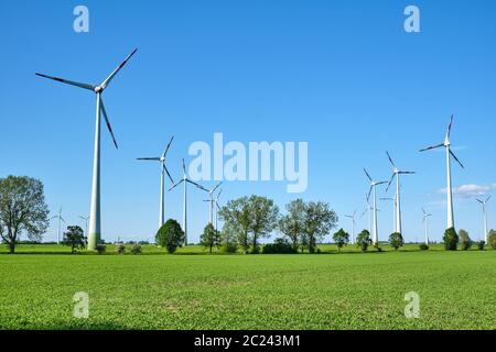 Windenergieanlagen und grüne Felder in Deutschland gesehen Stockfoto