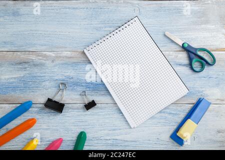 Die Schule Kinder Konzept. farbstifte oder Buntstifte, Schere, Hefter und Notizblock auf blaue und weiße Farbspuren vintage Holz- Hintergrund. Stockfoto