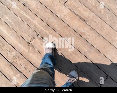 Schuhe auf Holzboden von oben, Sneaker auf Holzboden Hintergrund mit Licht und Schatten Stockfoto