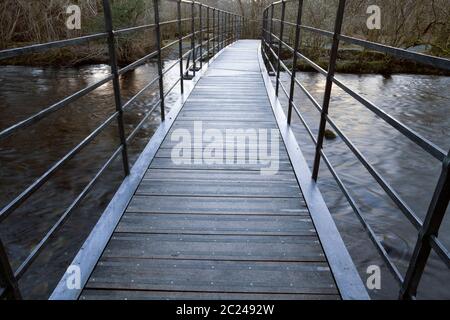 Die neue Metallbrücke über den Fluss Rothay bei Grasmere im Herbst, Cumbria, UK Stockfoto