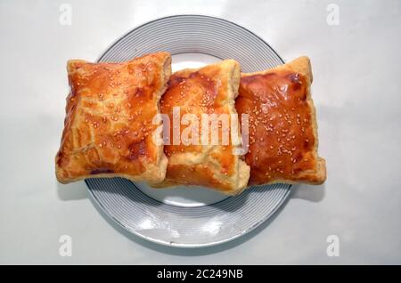 Rechteckige khachapuri in einer weißen Platte. Khachapuri. Georgische nationale Kuchen khachapuri mit Ei und Käse in der weißen Platte. Khachapuri geschichtet Stockfoto