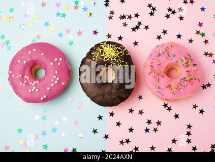 Runde Donuts mit verschiedenen Füllungen und Streuseln auf eine abstrakte Farbe Hintergrund mit festlichen Dekor, Banner Stockfoto