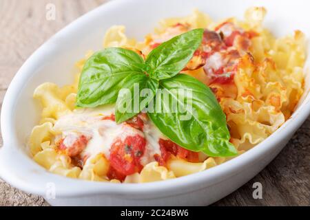 Pasta Gratin auf Holz mit Wein Stockfoto