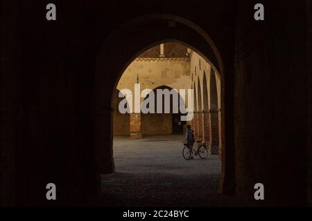 Ein junger Mann mit Fahrrad in Schloss Visconteo in Pandino, Lombardei, Italien Stockfoto