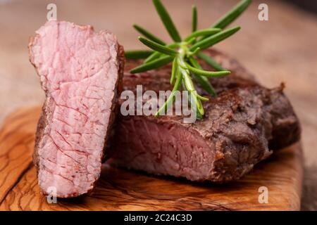 Gegrilltes Steak auf Holz mit Rosmarin Stockfoto