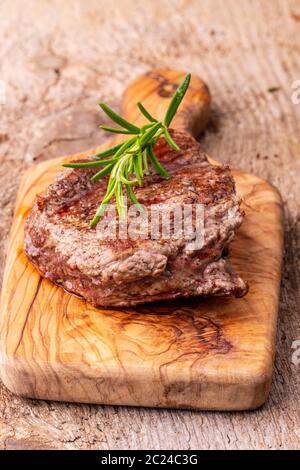 Gegrilltes Steak auf Holz mit Rosmarin Stockfoto