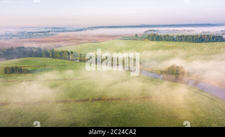 Sommer Natur Landschaft Luftbild Panorama. Morgennebel über den Fluss, Wiese und Wald. Natur Sonnenlicht Szene bei Nebel Sonnenaufgang. Belarus, Europa Stockfoto