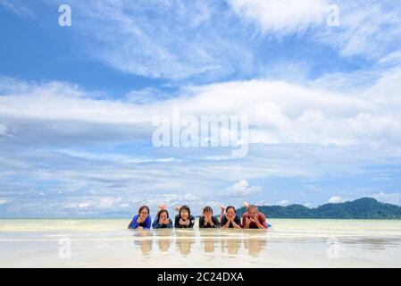 Glückliche Familie liegt zusammen am Strand, Thailand Stockfoto