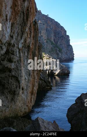 Steile Klippe im blauen Meer in dunkler Schlucht Stockfoto