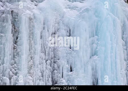 Textur von blauen Eiszapfen auf eisigen Wand aus Felsen Stockfoto