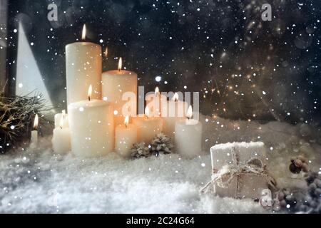 Weihnachtsdekoration mit brennenden Kerzen in einer verschneiten Winternacht Stockfoto