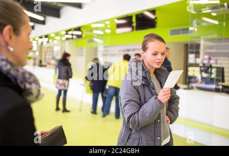 Junge Frau auf der Suche nach den richtigen Pillen / ihr Rezept in einer modernen Apotheke (flache DOF; Farbe getönten Bild) Stockfoto