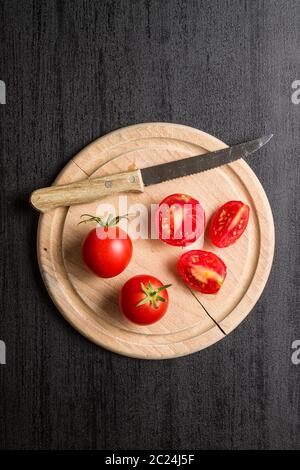 Rote Tomaten in Scheiben geschnitten auf Schwarz. Ansicht von oben. Stockfoto