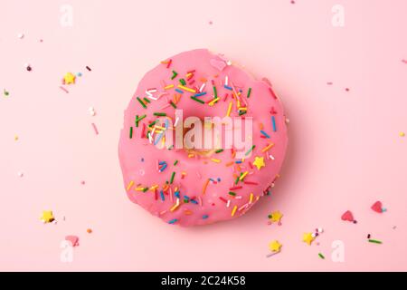 Rosa runde Donut mit bunten Streuseln auf einem hellen Hintergrund, Ansicht von oben Stockfoto