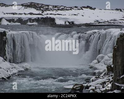 Schnee und Eis am Wasserfall Dettifoss in Island. Foto von März Stockfoto