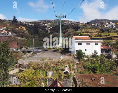 Blick auf die Häuser und Marktgärten von monte von der Seilbahn, die den Berg von funchal hinauf fährt Stockfoto