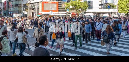 Massenmassen, die über die berühmte Shibuya Fußgängerüberfahrt, Tokio, Japan, laufen. Stockfoto