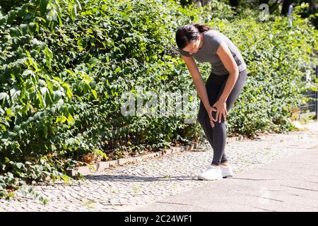 Nahaufnahme einer weiblichen Jogger mit Schmerzen im Knie Stockfoto