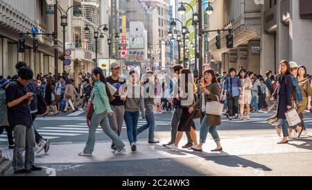 Massenmassen, die über die berühmte Shibuya Fußgängerüberfahrt, Tokio, Japan, laufen. Stockfoto