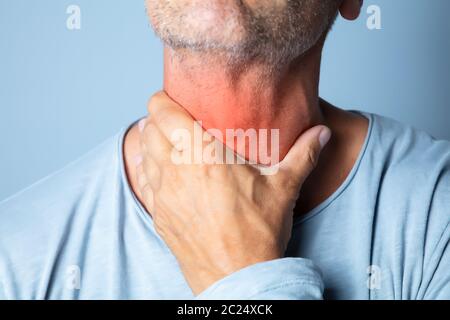 Close-up In eines Mannes Hand berühren Ihr Halsschmerzen Stockfoto