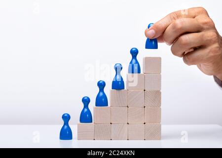 Unternehmer setzen Blau menschliche Figur auf den Holzblock Stockfoto