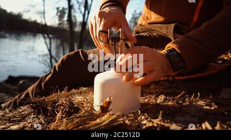 Das Thema des Tourismus ist Wandern und Reisen in der Natur. Hände EIN kaukasischer Mann verwendet Ausrüstung, um Essen draußen zu kochen. Ein Tourist ins Stockfoto