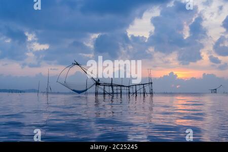 Schönen sonnenaufgang Meereslandschaft mit chinesischen Fischernetze oder Shore betätigte Hubvorrichtung Netze in Phatthalung, Thailand Stockfoto