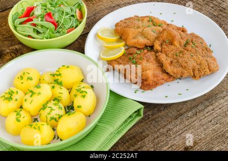 Deutsche Schnitzel mit Kartoffeln, Zwiebeln und Zitrone Stockfoto