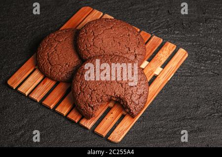 Schokolade Haferflocken Cookies drei Stücke ein Bissen liegt auf einem Bambusplatte auf schwarzem Beton Stockfoto