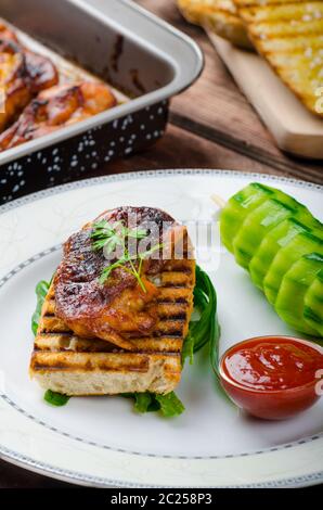 Klebrige Huhn mit pikanter Sauce, geröstete Panini mit grobkörnigem Salz und Olivenöl sowie Gurke kebab Stockfoto