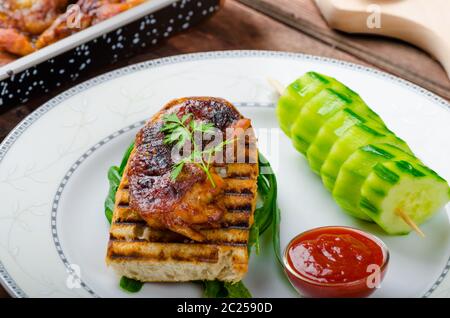 Klebrige Huhn mit pikanter Sauce, geröstete Panini mit grobkörnigem Salz und Olivenöl sowie Gurke kebab Stockfoto