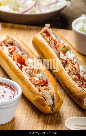 Schweinesandwich, lange gebackenes Schweinefleisch, in frischem Baguette mit frischem Salat und heiße Sause gezogen gezogen Stockfoto