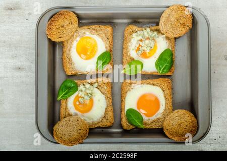 Gebackene Bullauge Eiern auf Vollkorn Toast mit Spinat und Blauschimmelkäse an der Spitze Stockfoto