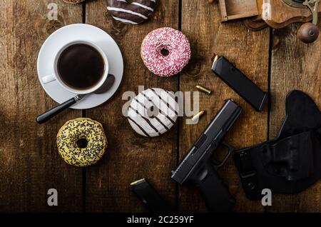 Amerikanische Polizisten Morgen, Donuts, Saft, frischen schwarzen Kaffee und seine Waffe Stockfoto