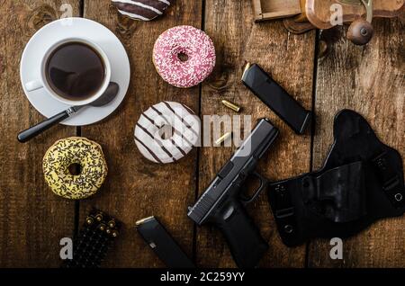 Amerikanische Polizisten Morgen, Donuts, Saft, frischen schwarzen Kaffee und seine Waffe Stockfoto