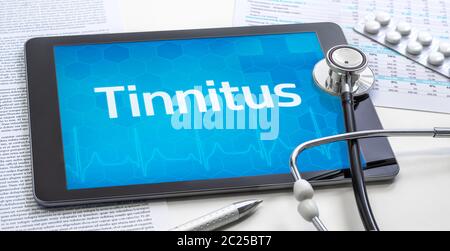 Das Wort Tinnitus auf dem Display eines Tablet Stockfoto