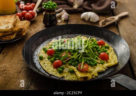 Gesunden Omelette mit Gemüse - Erbsen und Sonnenblumen Microgreens toast Cherry-Tomaten Stockfoto