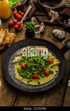 Gesunden Omelette mit Gemüse - Erbsen und Sonnenblumen Microgreens toast Cherry-Tomaten Stockfoto