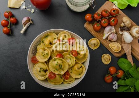 Hausgemachte Tortellini gefüllt, Pilze und Tomaten mit Feta-Käse Stockfoto