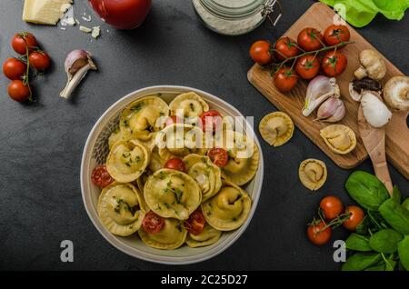 Hausgemachte Tortellini gefüllt, Pilze und Tomaten mit Feta-Käse Stockfoto